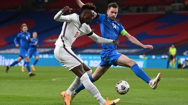 LONDON, ENGLAND - NOVEMBER 18: Tammy Abraham of England is challenged by Kari Arnason of Iceland during the UEFA Nations League group stage match between England and Iceland at Wembley Stadium on November 18, 2020 in London, England. Football Stadiums around Europe remain empty due to the Coronavirus Pandemic as Government social distancing laws prohibit fans inside venues resulting in fixtures being played behind closed doors. (Photo by Neil Hall - Pool/Getty Images)