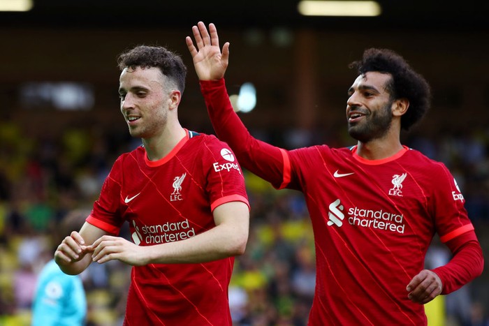 NORWICH, ENGLAND - AUGUST 14: Diogo Jota of Liverpool celebrates with teammate Mohamed Salah after scoring their sides first goal during the Premier League match between Norwich City and Liverpool at Carrow Road on August 14, 2021 in Norwich, England. (Photo by Marc Atkins/Getty Images)