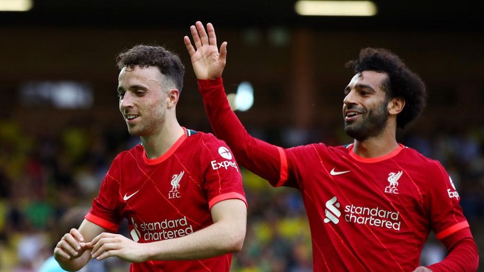 NORWICH, ENGLAND - AUGUST 14: Diogo Jota of Liverpool celebrates with teammate Mohamed Salah after scoring their sides first goal during the Premier League match between Norwich City and Liverpool at Carrow Road on August 14, 2021 in Norwich, England. (Photo by Marc Atkins/Getty Images)