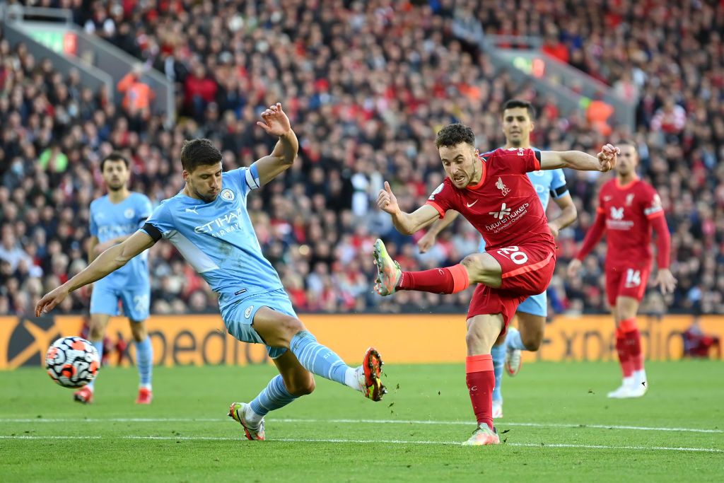 LIVERPOOL, ENGLAND - OCTOBER 03: Diogo Jota of Liverpool shoots whilst under pressure from Ruben Dias of Manchester City during the Premier League match between Liverpool and Manchester City at Anfield on October 03, 2021 in Liverpool, England. (Photo by Michael Regan/Getty Images)