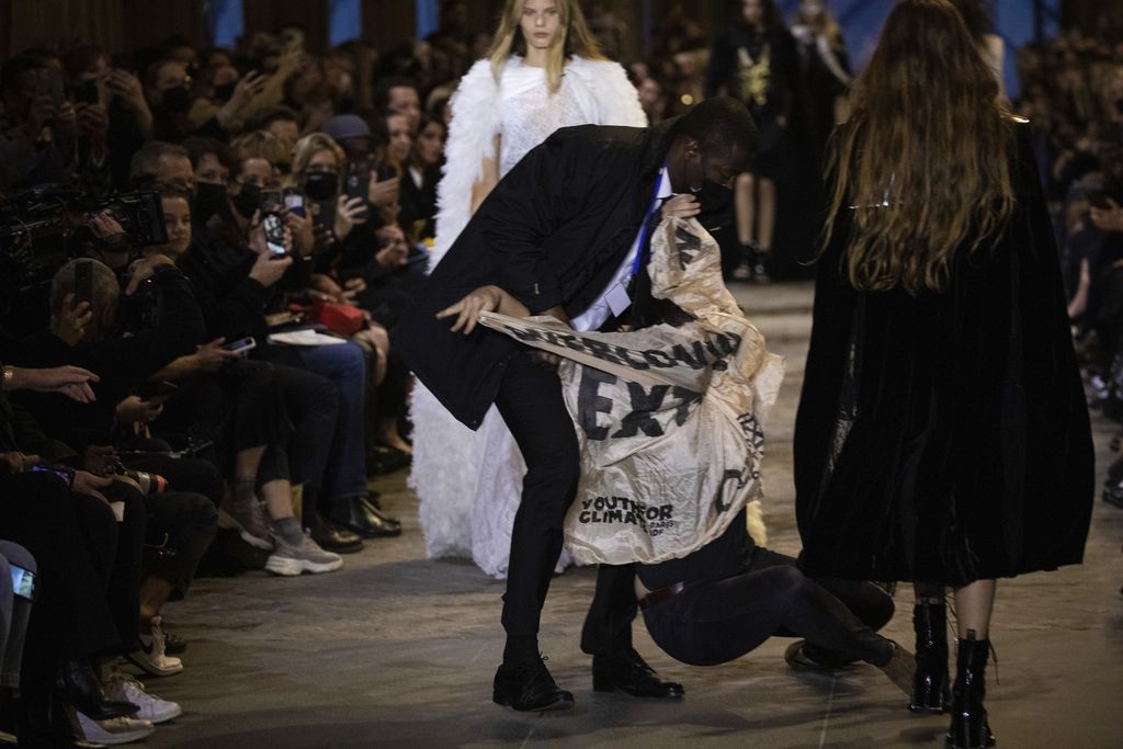 A protestor is removed from the runway during the Louis Vuitton Spring-Summer 2022 ready-to-wear fashion show presented in Paris, Tuesday, Oct. 5, 2021. (Photo by Vianney Le Caer/Invision/AP)
