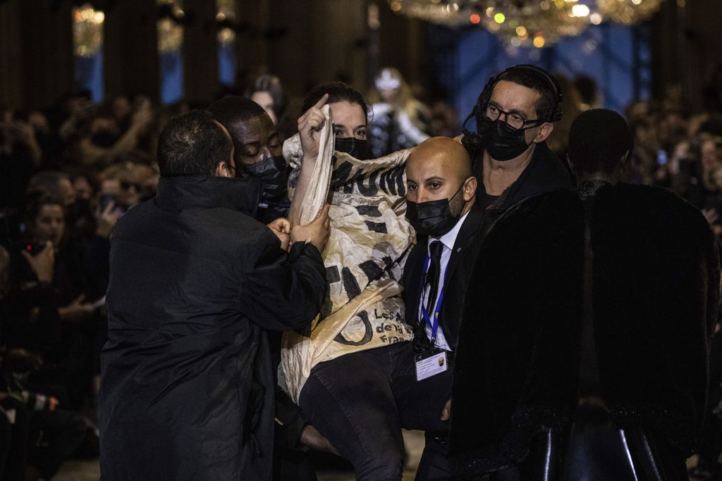 A protestor is removed from the runway during the Louis Vuitton Spring-Summer 2022 ready-to-wear fashion show presented in Paris, Tuesday, Oct. 5, 2021. (Photo by Vianney Le Caer/Invision/AP)