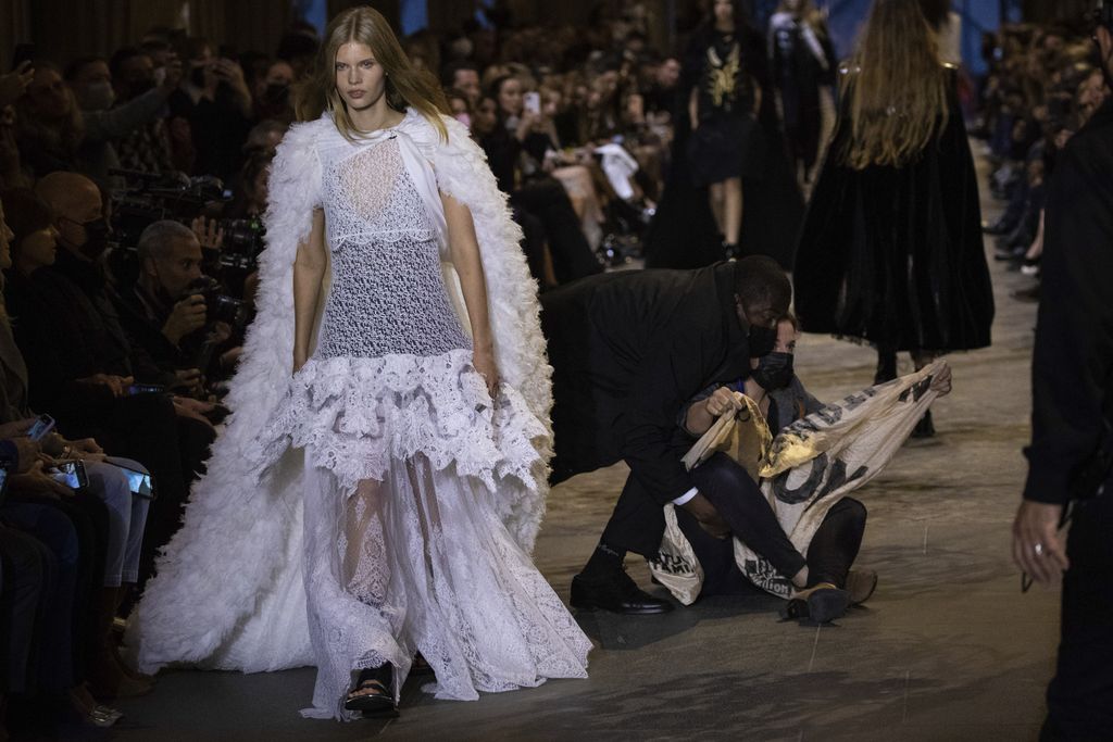 A protestor is removed from the runway during the Louis Vuitton Spring-Summer 2022 ready-to-wear fashion show presented in Paris, Tuesday, Oct. 5, 2021. (Photo by Vianney Le Caer/Invision/AP)