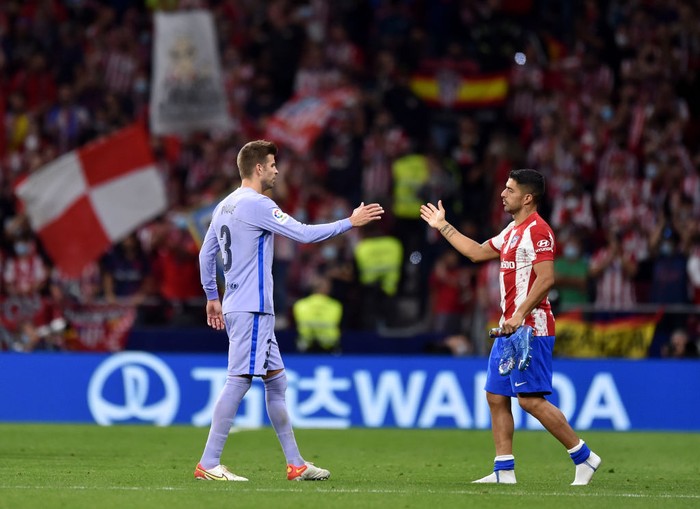 MADRID, SPAIN - OCTOBER 02: Gerard Pique of FC Barcelona and Luis Suarez of Atletico Madrid interact after the La Liga Santander match between Club Atletico de Madrid and FC Barcelona at Estadio Wanda Metropolitano on October 02, 2021 in Madrid, Spain. (Photo by Denis Doyle/Getty Images)