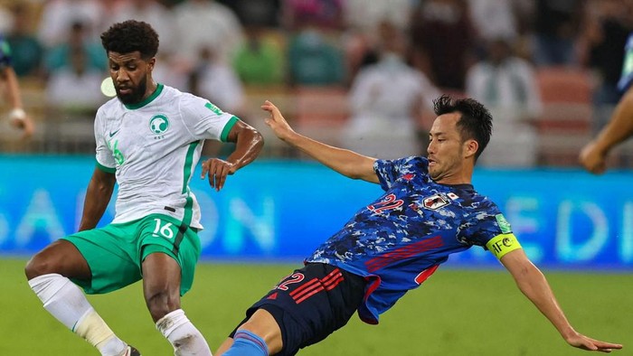 Japans defender Maya Yoshida (R) vies for the ball with Saudis midfielder Sami al-Najei during the 2022 Qatar World Cup Asian Qualifiers football match between Saudi Arabia and Japan, at the King Abdullah Sport City Stadium in Jeddah, on October 7, 2021. (Photo by - / AFP)