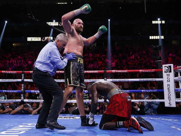 Tyson Fury, of England, knocks down Deontay Wilder in a heavyweight championship boxing match Saturday, Oct. 9, 2021, in Las Vegas. (AP Photo/Chase Stevens)