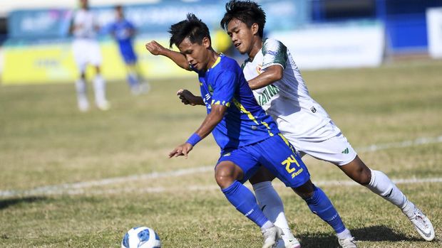 Pesepak bola Jawa Barat Yoga Adiyatama (kiri) berusaha melewati hadangan pesepak bola Jawa Timur Rezky Renaldi El Has (kanan) pada babak enam besar Sepak Bola Putra PON Papua di Stadion Barnabas Youwe, Sentani, Kabupaten Jayapura, Papua, Minggu (10/10/2021). ANTARA FOTO/Zabur Karuru/wsj.