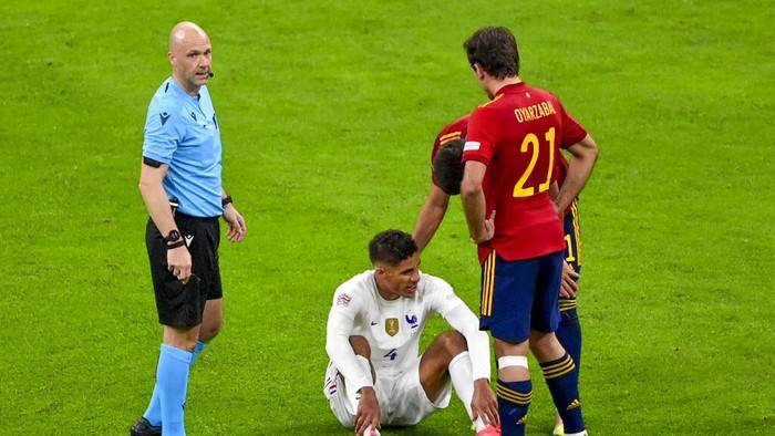 Frances Raphael Varane sits on the pitch after an injury during the UEFA Nations League final soccer match between Spain and France at the San Siro stadium, in Milan, Italy, Sunday, Oct. 10, 2021. (Miguel Medina/Pool Photo via AP)