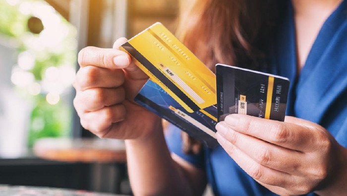 Closeup image of a woman holding and choosing credit card to use