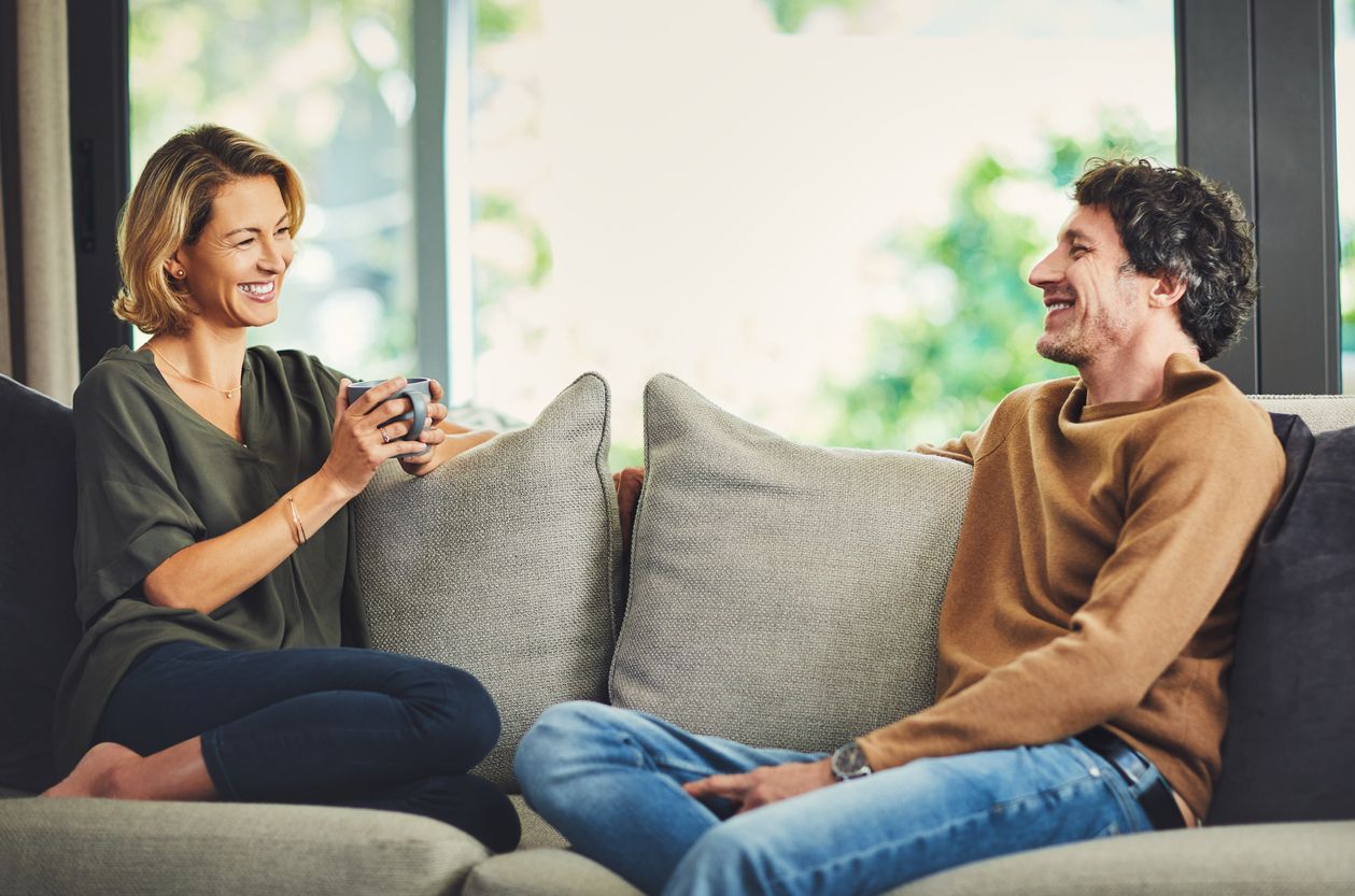 Shot of a mature couple chatting and having coffee while relaxing on the sofa at home