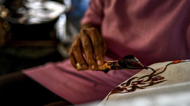 Produksi Batik Tulis Aceh A worker creates batik designs at a workshop in Banda Aceh on October 13, 2021. 2021. (Photo by Chaideer MAHYUDDIN / AFP)
