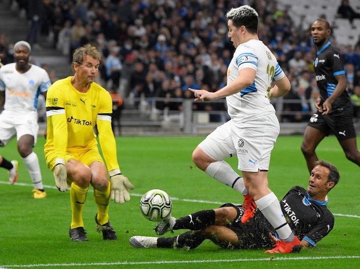 French Former football player Samir Nasri (C) fights for the ball with German former goalkeeper Jens Lehmann (R) during the charity 