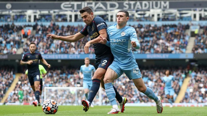 MANCHESTER, ENGLAND - OCTOBER 16: Matthew Lowton of Burnley and Phil Foden of Manchester City battle for the ball during the Premier League match between Manchester City and Burnley at Etihad Stadium on October 16, 2021 in Manchester, England. (Photo by Jan Kruger/Getty Images)
