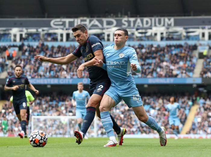 MANCHESTER, ENGLAND - OCTOBER 16: Matthew Lowton of Burnley and Phil Foden of Manchester City battle for the ball during the Premier League match between Manchester City and Burnley at Etihad Stadium on October 16, 2021 in Manchester, England. (Photo by Jan Kruger/Getty Images)