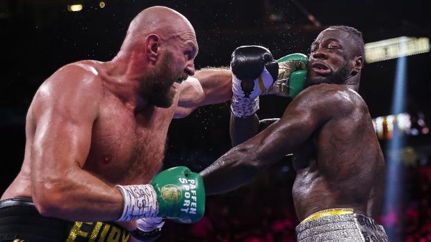 Tyson Fury, of England, lands a left to Deontay Wilder in a heavyweight championship boxing match Saturday, Oct. 9, 2021, in Las Vegas. (AP Photo/Chase Stevens)