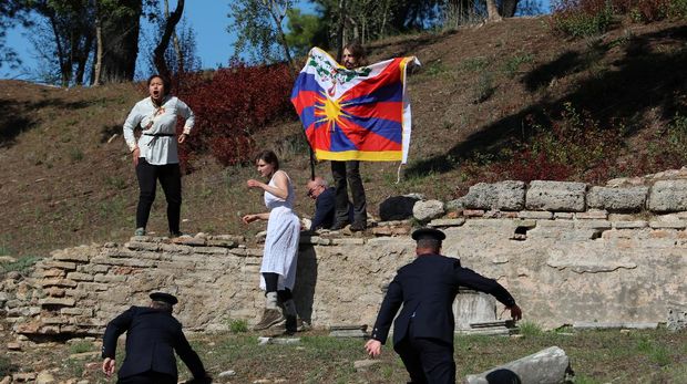 Winter Olympics - Lighting ceremony of the Olympic flame for the Beijing 2022 Winter Olympics - Ancient Olympia, Olympia, Greece - October 18, 2021 A protester holds a Tibetan flag during the Olympic flame lighting ceremony for the Beijing 2022 Winter Olympics REUTERS/Costas Baltas     TPX IMAGES OF THE DAY