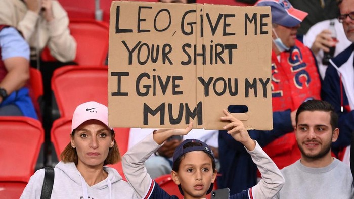 Paris Saint-Germains (PSG) supporter holds a placard prior the UEFA Champions League first round group A football match between Paris Saint-Germains (PSG) and RB Leipzig, at The Parc des Princes stadium, in Paris, on October 19, 2021. (Photo by FRANCK FIFE / AFP)