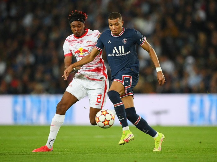 PARIS, FRANCE - OCTOBER 19: Kylian Mbappe of Paris Saint-Germain battles for possession with Mohamed Simakan of RB Leipzig during the UEFA Champions League group A match between Paris Saint-Germain and RB Leipzig at Parc des Princes on October 19, 2021 in Paris, France. (Photo by Matthias Hangst/Getty Images)
