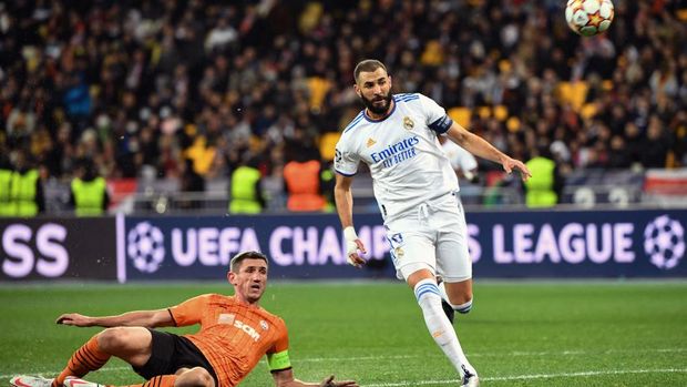 Shakhtar Donetsk's Ukrainian defender Serhiy Kryvtsov scores an own goal next to Real Madrid's French forward Karim Benzema during the UEFA Champions League football match between Shakhtar Donetsk and Real Madrid at the Olympic Stadium in Kiev on October 19, 2021. (Photo by Sergei SUPINSKY / AFP)