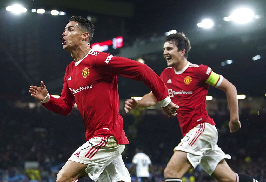 Manchester United's Cristiano Ronaldo celebrates scoring their side's third goal of the game with Harry Maguire during the Champions League Group F soccer match between Manchester United and Atalanta at Old Trafford, Manchester, England, Wednesday, Oct. 20, 2021. (Martin Rickett/PA via AP)