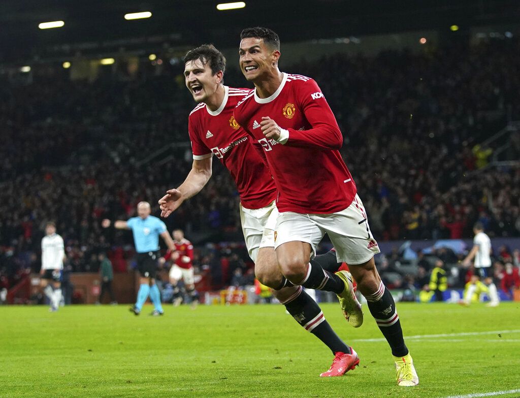 Manchester United's Cristiano Ronaldo, right, celebrates scoring their side's third goal of the game with Harry Maguire during the Champions League Group F soccer match between Manchester United and Atalanta at Old Trafford, Manchester, England, Wednesday, Oct. 20, 2021. (Martin Rickett/PA via AP)