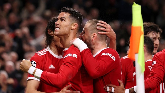 MANCHESTER, ENGLAND - OCTOBER 20: Cristiano Ronaldo of Manchester United celebrates with teammates Luke Shaw and Edinson Cavani after scoring their sides third goal during the UEFA Champions League group F match between Manchester United and Atalanta at Old Trafford on October 20, 2021 in Manchester, England. (Photo by Naomi Baker/Getty Images)