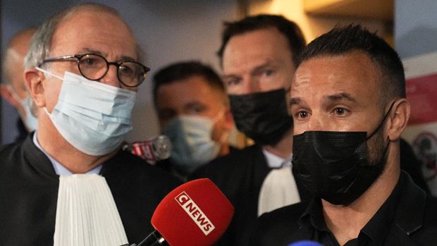 Former France's soccer player Mathieu Valbuena, right, and his lawyer Paul-Albert Iweins answer journalists outside the courtroom Wednesday, Oct. 20, 2021 in Versailles, west of Paris. Real Madrid forward Karim Benzema wasn't present for the opening Wednesday of his three-day trial on France for involvement in an alleged attempt to blackmail his former France teammate Mathieu Valbuena over a sex tape. (AP Photo/Michel Euler)