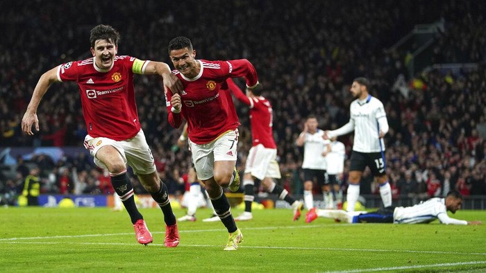 Manchester Uniteds Cristiano Ronaldo, second left, celebrates scoring their sides third goal of the game with Harry Maguire during the Champions League Group F soccer match between Manchester United and Atalanta at Old Trafford, Manchester, England, Wednesday, Oct. 20, 2021. (Martin Rickett/PA via AP)