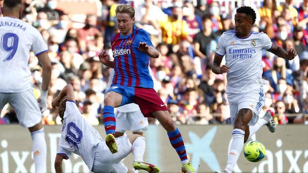 Real Madrid's Vinicius Junior, right, and Real Madrid's Luka Modric, 2nd left, challenge Barcelona's Frenkie de Jong during the Spanish La Liga soccer match between FC Barcelona and Reaal Madrid at the Camp Nou stadium in Barcelona, Spain, Sunday, Oct. 24, 2021. (AP Photo/Joan Monfort)