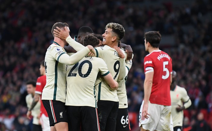 MANCHESTER, ENGLAND - OCTOBER 24: Mohamed Salah of Liverpool (obscured) celebrates after scoring their sides fourth goal with Jordan Henderson, Roberto Firmino and team mates during the Premier League match between Manchester United and Liverpool at Old Trafford on October 24, 2021 in Manchester, England. (Photo by Michael Regan/Getty Images)