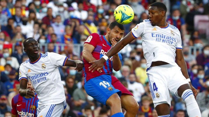 Barcelonas Sergio Aguero, center, challenges Real Madrids David Alaba during the Spanish La Liga soccer match between FC Barcelona and Real Madrid at the Camp Nou stadium in Barcelona, Spain, Sunday, Oct. 24, 2021. (AP Photo/Joan Monfort)