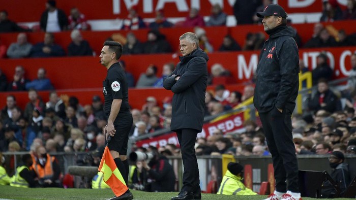 Manchester Uniteds manager Ole Gunnar Solskjaer, center, and Liverpools manager Jurgen Klopp, right, stand by the touchline during the English Premier League soccer match between Manchester United and Liverpool at Old Trafford in Manchester, England, Sunday, Oct. 24, 2021. (AP Photo/Rui Vieira)