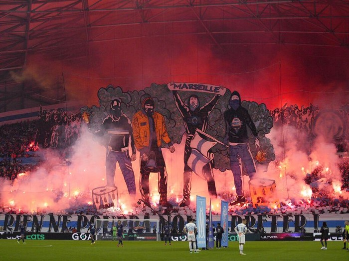 Marseille fans hold flares as they fill the stands during the French League One soccer match between Marseille and Paris Saint-Germain in Marseille, France, Sunday, Oct. 24, 2021. (AP Photo/Daniel Cole)