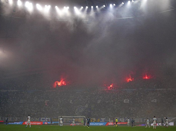 Marseille fans hold flares as they fill the stands during the French League One soccer match between Marseille and Paris Saint-Germain in Marseille, France, Sunday, Oct. 24, 2021. (AP Photo/Daniel Cole)