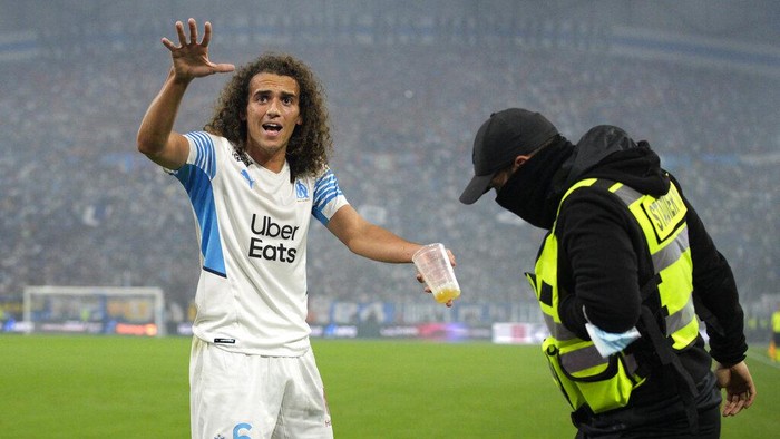 Marseilles Matteo Guendouzi pleads with fans to stop throwing objects during the French League One soccer match between Marseille and Paris Saint-Germain in Marseille, France, Sunday, Oct. 24, 2021. (AP Photo/Daniel Cole)