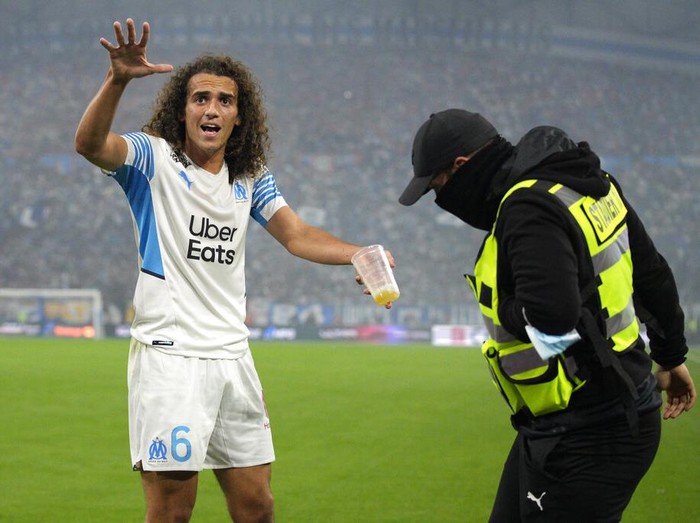 Marseille's Matteo Guendouzi pleads with fans to stop throwing objects during the French League One soccer match between Marseille and Paris Saint-Germain in Marseille, France, Sunday, Oct. 24, 2021. (AP Photo/Daniel Cole)