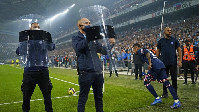 Marseille vs PSG, Neymar Shields are held up to protect PSG's Neymar from objects possibly being thrown as he goes to take a corner during the French League One soccer match between Marseille and Paris Saint-Germain in Marseille, France, Sunday, Oct. 24, 2021. (AP Photo/Daniel Cole)