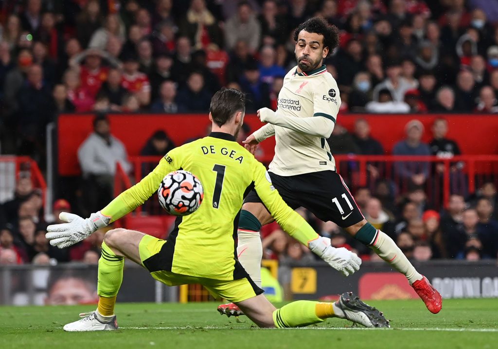Mohamed Salah MANCHESTER, ENGLAND - OCTOBER 24: Mohamed Salah of Liverpool shoots past Manchester United goalkeeper David De Gea to score his hat trick during the Premier League match between Manchester United and Liverpool at Old Trafford on October 24, 2021 in Manchester, England. (Photo by Shaun Botterill/Getty Images)