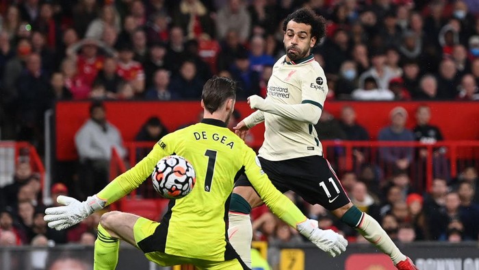 MANCHESTER, ENGLAND - OCTOBER 24:  Mohamed Salah of Liverpool shoots past Manchester United goalkeeper David De Gea to score his hat trick during the Premier League match between Manchester United and Liverpool at Old Trafford on October 24, 2021 in Manchester, England. (Photo by Shaun Botterill/Getty Images)