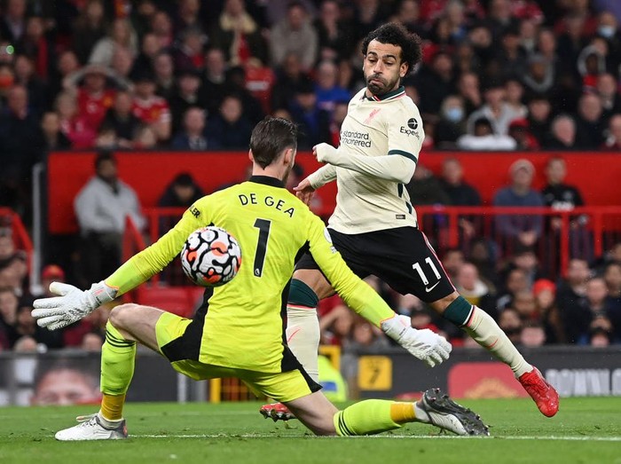 MANCHESTER, ENGLAND - OCTOBER 24:  Mohamed Salah of Liverpool shoots past Manchester United goalkeeper David De Gea to score his hat trick during the Premier League match between Manchester United and Liverpool at Old Trafford on October 24, 2021 in Manchester, England. (Photo by Shaun Botterill/Getty Images)