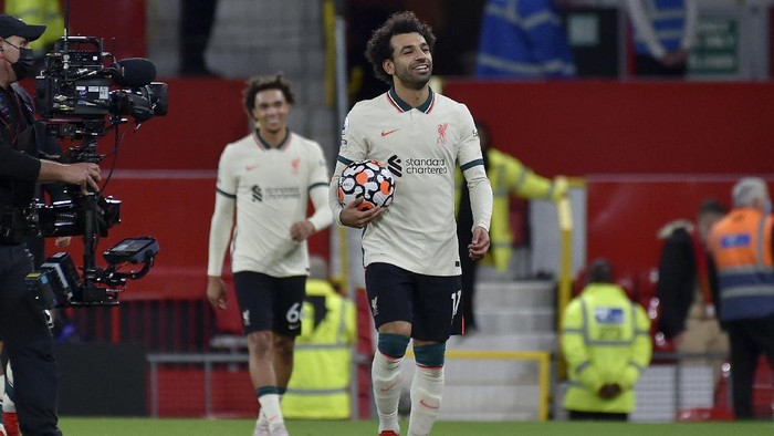 Liverpools Mohamed Salah leaves the field with the match ball at the end of the English Premier League soccer match between Manchester United and Liverpool at Old Trafford in Manchester, England, Sunday, Oct. 24, 2021. Salah scored three goals in Liverpools 5-0 win. (AP Photo/Rui Vieira)