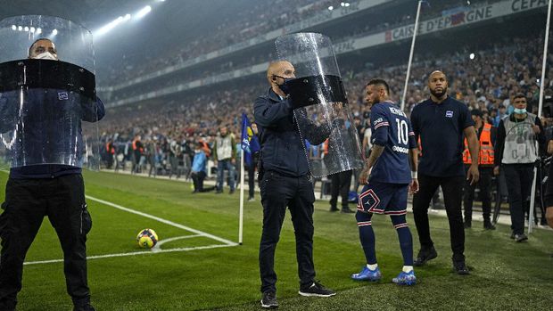 Shields are held up to protect PSG's Neymar from objects possibly being thrown as he goes to take a corner during the French League One soccer match between Marseille and Paris Saint-Germain in Marseille, France, Sunday, Oct. 24, 2021. (AP Photo/Daniel Cole)