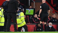 Wasit Anthony Taylor mengacungkan kartu kuning, tapi kemudian diprotes para pemain Liverpool. Selanjutnya, Taylor mengecek VAR karena ada indikasi pelanggaran berat (Getty Images/Michael Regan)