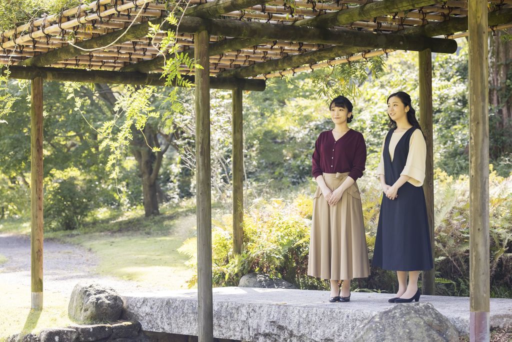 In this photo provided Saturday, Oct, 23, 2021, by the Imperial Household Agency of Japan, Japan's Princess Mako, left, the eldest daughter of Crown Prince Akishino and Crown Princess Kiko, strolls with her younger sister Princess Kako, at the garden of their Akasaka imperial property residence in Tokyo, Japan on Oct. 6, 2021, ahead of her 30th birthday on Oct. 23, 2021 and her marriage on Oct. 26, 2021.(The Imperial Household Agency of Japan via AP)