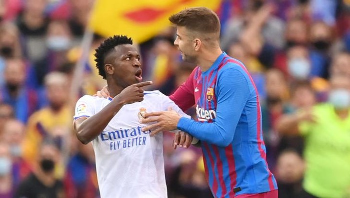 BARCELONA, SPAIN - OCTOBER 24: Vinicius Junior of Real Madrid clashes with Gerard Pique of FC Barcelona during the LaLiga Santander match between FC Barcelona and Real Madrid CF at Camp Nou on October 24, 2021 in Barcelona, Spain. (Photo by David Ramos/Getty Images)