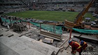 Pekerja menyelasaikan pengerjaan pemasangan rumput di lapangan utama kawasan Jakarta International Stadium, Papanggo, Jakarta Utara, Selasa (26/10).
