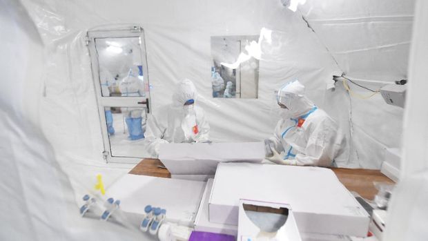 Workers in protective suits work inside a makeshift nucleic acid testing laboratory during a mass testing following local cases of the coronavirus disease (COVID-19) in Lanzhou, Gansu province, China October 25, 2021. Picture taken October 25, 2021. cnsphoto via REUTERS   ATTENTION EDITORS - THIS IMAGE WAS PROVIDED BY A THIRD PARTY. CHINA OUT.