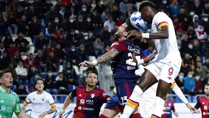 Romas Tammy Abraham, rightm and Cagliaris Luca Ceppitelli battle for the ball during the Italian serie A soccer match between Cagliari Calcio and AS Roma at Unipol Domus Stadium in Cagliari, Italy, Wednesday, Oct. 27, 2021. (Alessandro Tocco/dpa via AP)