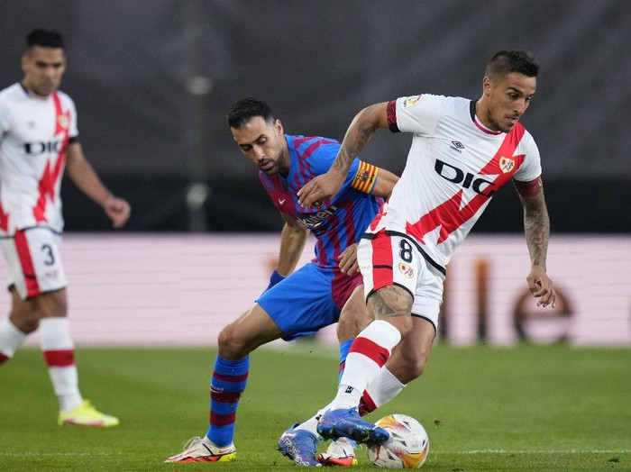 Rayos Oscar Trejo, right, fights for the ball with Barcelonas Sergio Busquets during a Spanish La Liga soccer match between Rayo Vallecano and FC Barcelona at the Vallecas stadium in Madrid, Spain, Wednesday, Oct. 27, 2021. (AP Photo/Manu Fernandez)