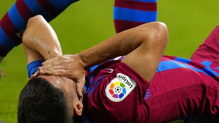 Barcelonas Jordi Alba grimaces in pain after a tackle during a Spanish La Liga soccer match between Rayo Vallecano and FC Barcelona at the Vallecas stadium in Madrid, Spain, Wednesday, Oct. 27, 2021. (AP Photo/Manu Fernandez)